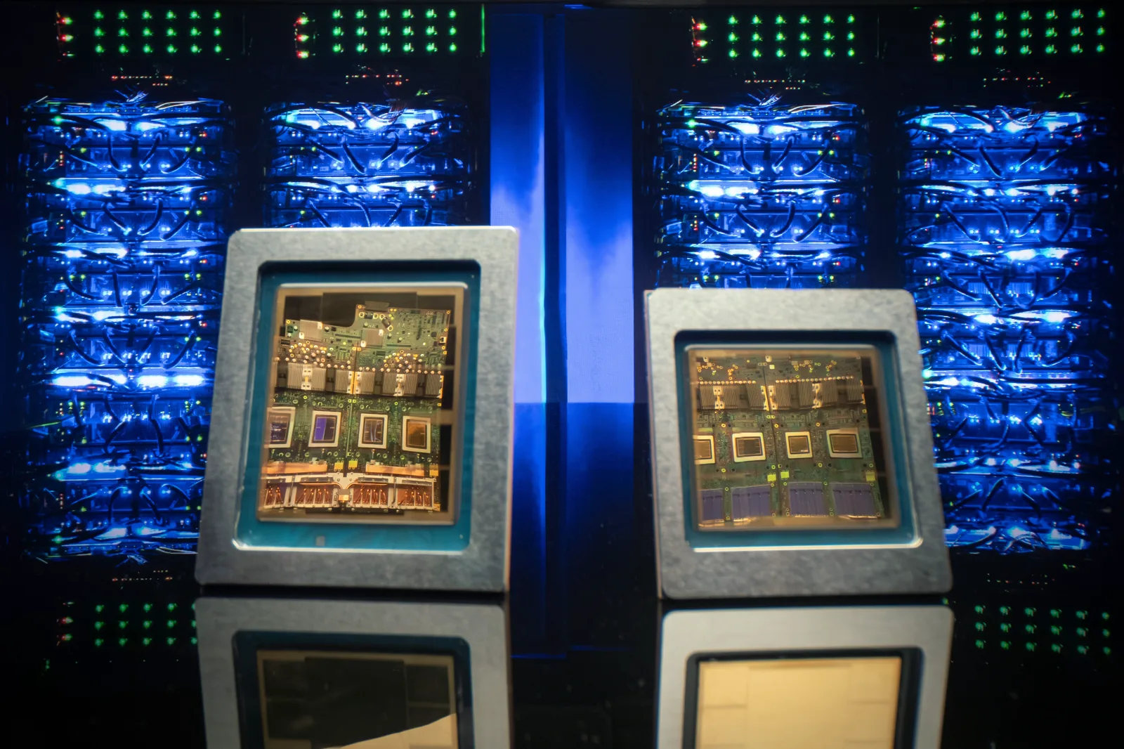 Two Google TPU processor boards displayed in front of glowing data center server racks.