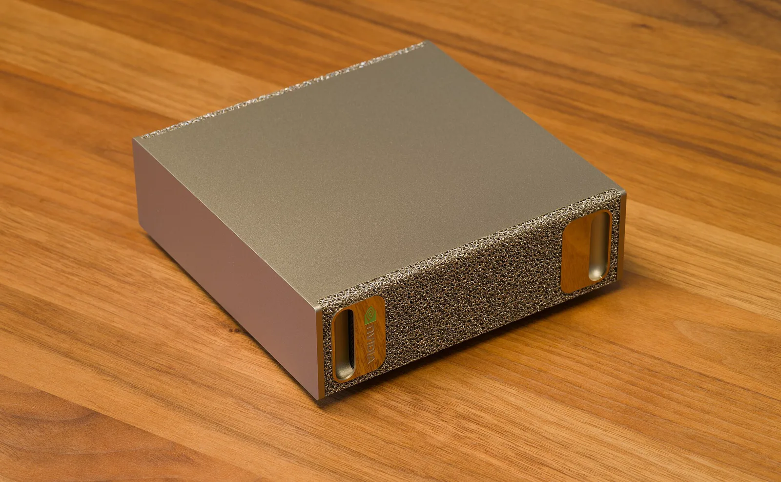 A compact Nvidia DGX Spark computer sits on a wooden tabletop.